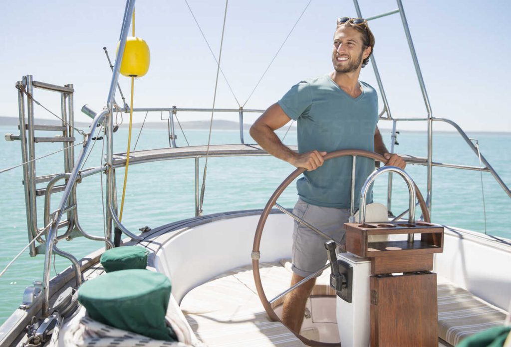 man-steering-sailboat-on-water-1024x697